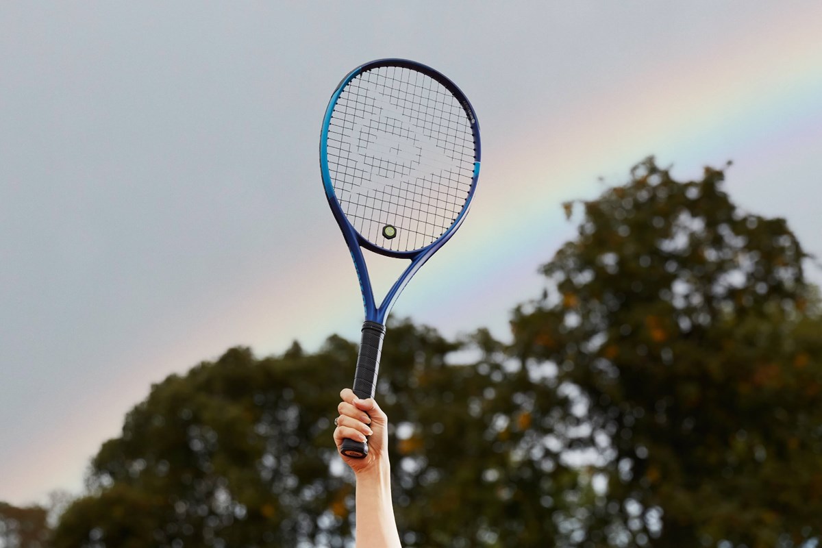 Tennis racket held up in front of rainbow.jpg